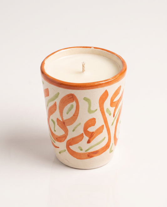Bougie Nour, petit format en terre cuite peint main (calligraphie orange + touches vert clair) sur fond neutre, collection Fès My Candles Vibes