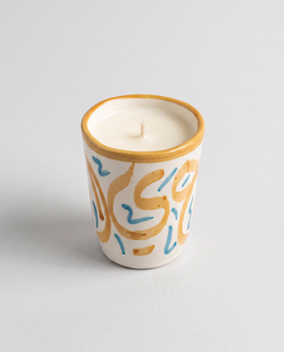 Bougie Safran, petit format en terre cuite peint main (calligraphie moutarde/ocre + touches bleues) sur fond neutre, collection Fès My Candles Vibes