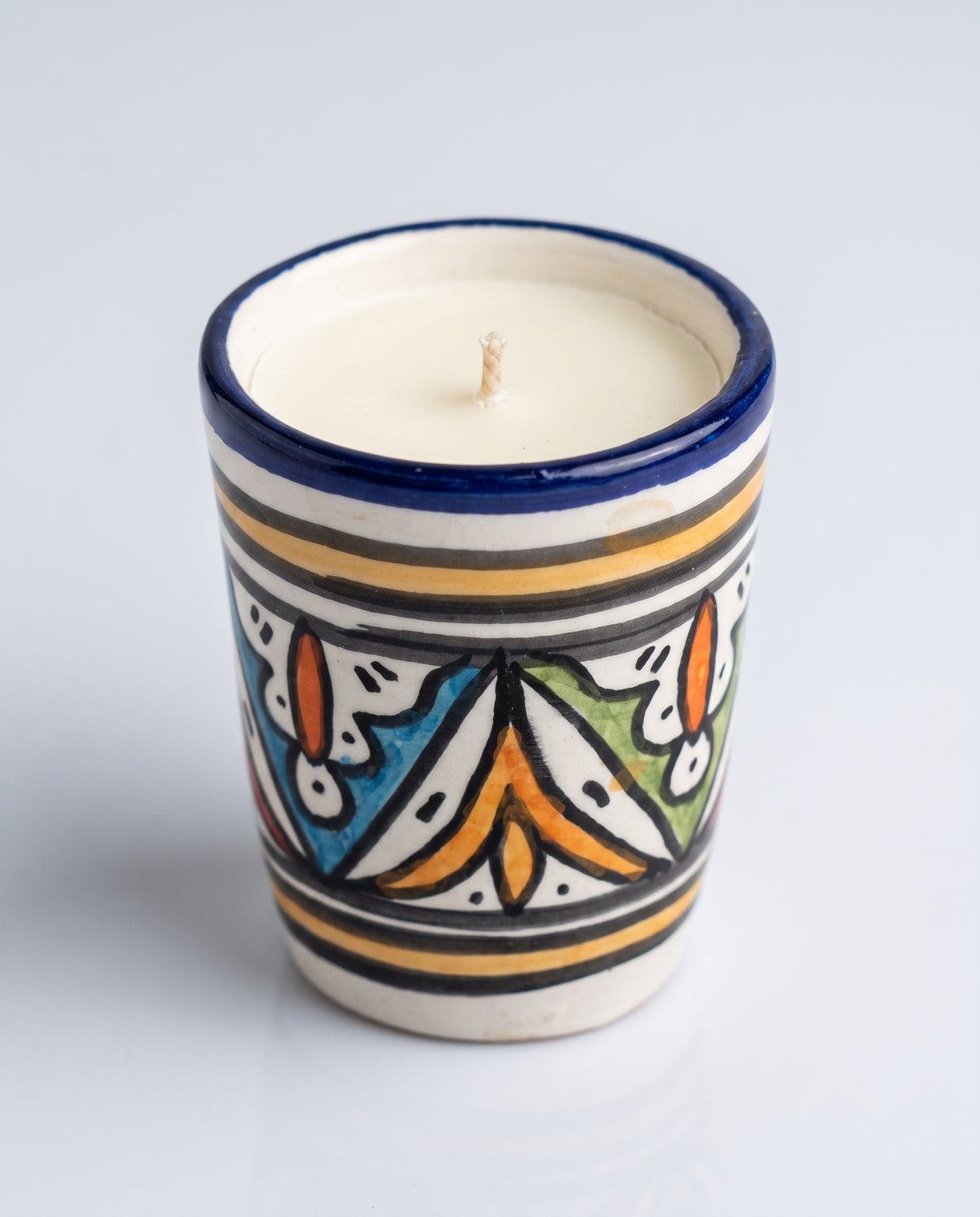 Bougie Widad, petit format en terre cuite peint main (frise florale géométrique multicolore, orange/bleu/vert, rebord bleu) sur fond neutre, collection Fès My Candles Vibes